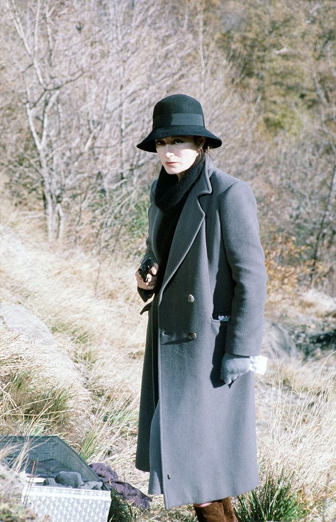 #74 Anouk Aimée holding a gun in a scene of the movie La tragedia di un uomo ridicolo by Bernardo Bertolucci, 1975.