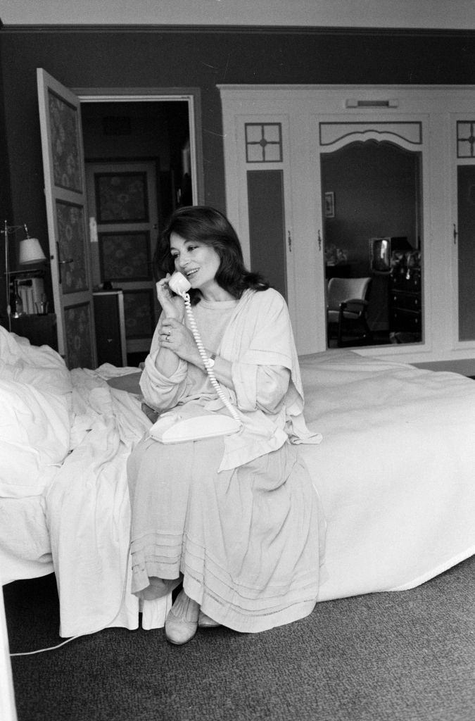 #32 Anouk Aimée telephoning, sitting on the bed in her bedroom, 1980.