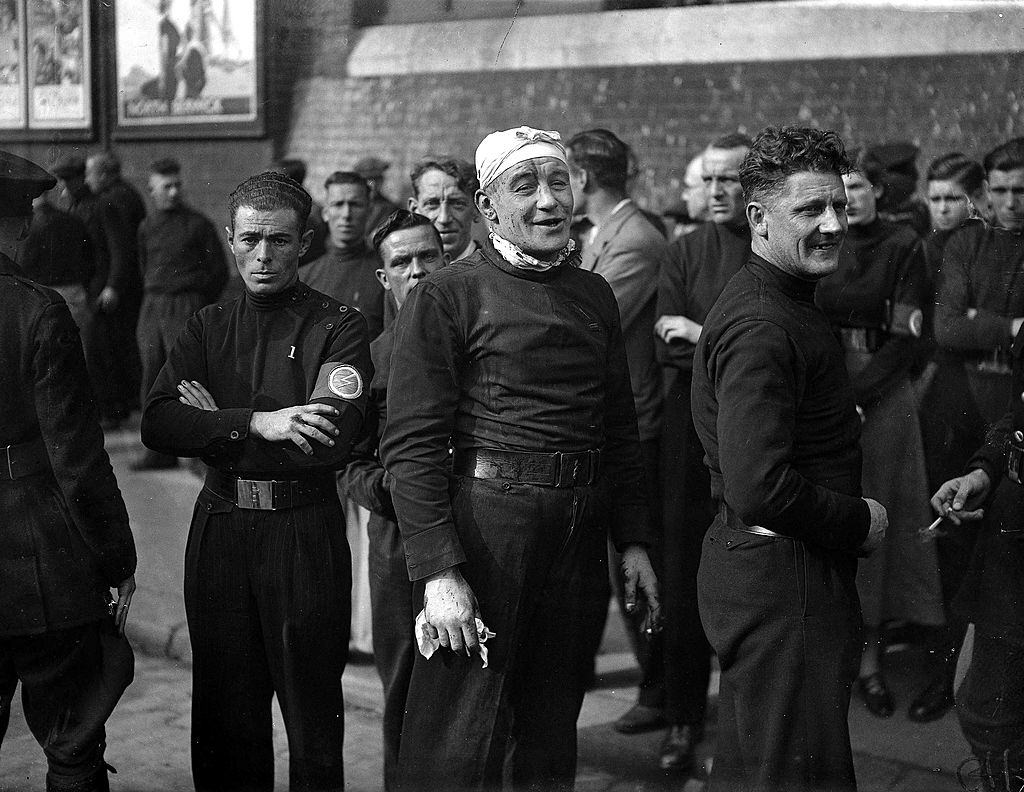 #9 His head bandaged after a blow from a cudgel, an injured British Fascist rejoins the ranks for a mass march through East London, 1936