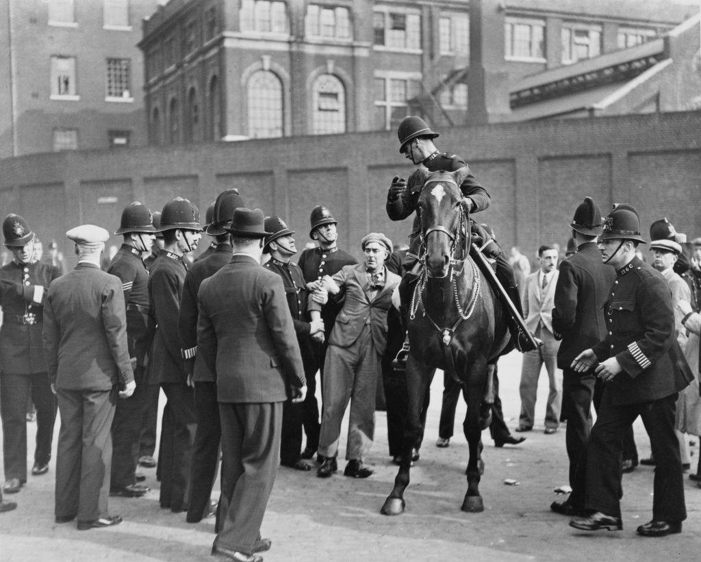#16 Police arrest a man during a British Union of Fascists demonstration on Royal Mint Street in the East End of London, England, 4th October 1936.