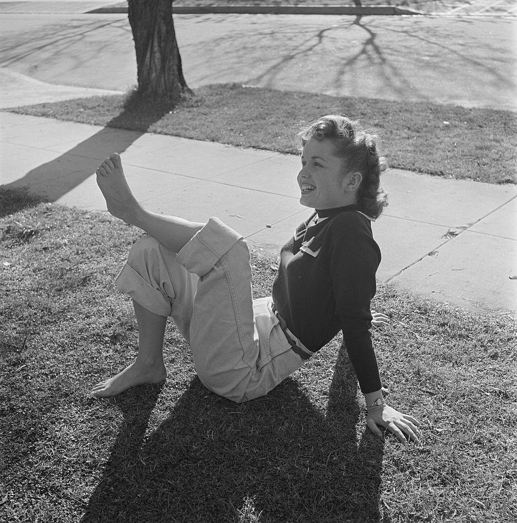 #28 Debbie Reynolds posing on the grass, 1950.