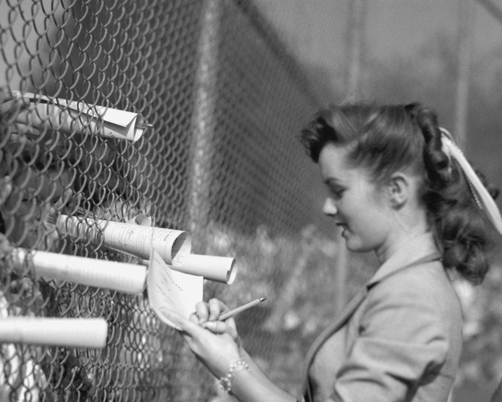 #1 Debbie Reynolds signs scorecards at a sporting event, 1950.