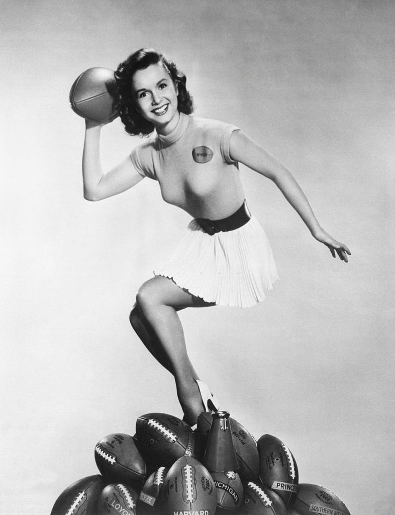 #11 Debbie Reynolds gets ready to throw a pass to kick off the football season, 1953.