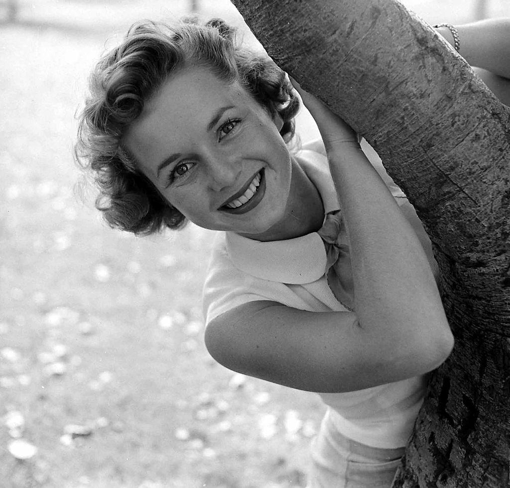 #2 Debbie Reynolds poses behind a tree, 1950.