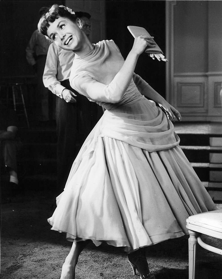 #58 Debbie Reynolds leaning and looking back in a scene from the film ‘The Tender Trap’, 1955.