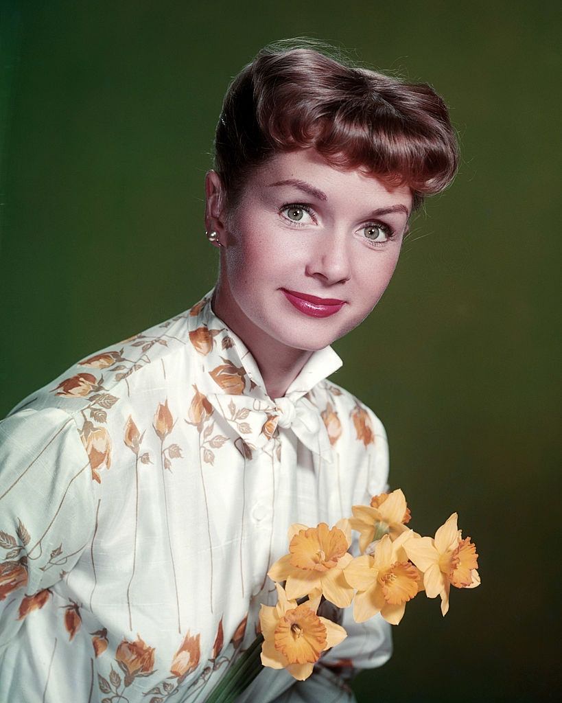 #59 Debbie Reynolds, holding a bunch of daffodils, 1955.
