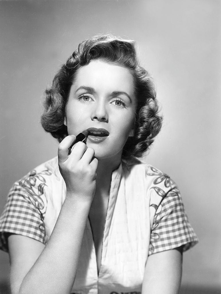 #16 Debbie Reynolds applying lipstick, 1955.