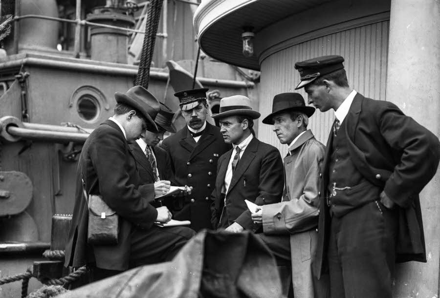 #19 Conservative MP Henry Herbert Stevens and Customs Inspector Malcolm Reid speak to members of the press.