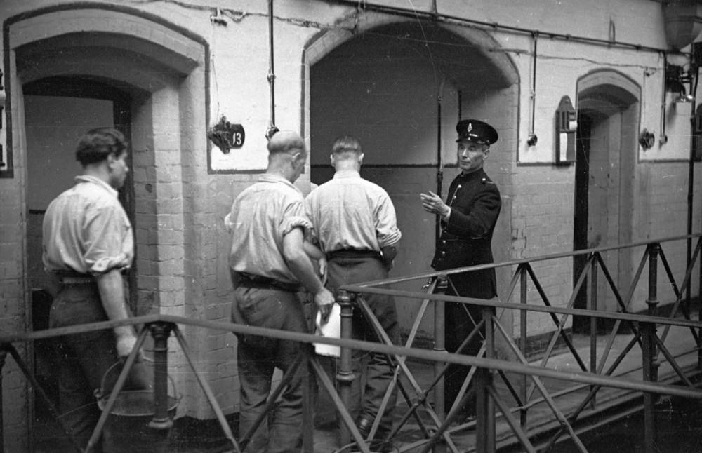 #2 A prison officer supervising prisoners as they take out their night-slops at Strangeways Prison.