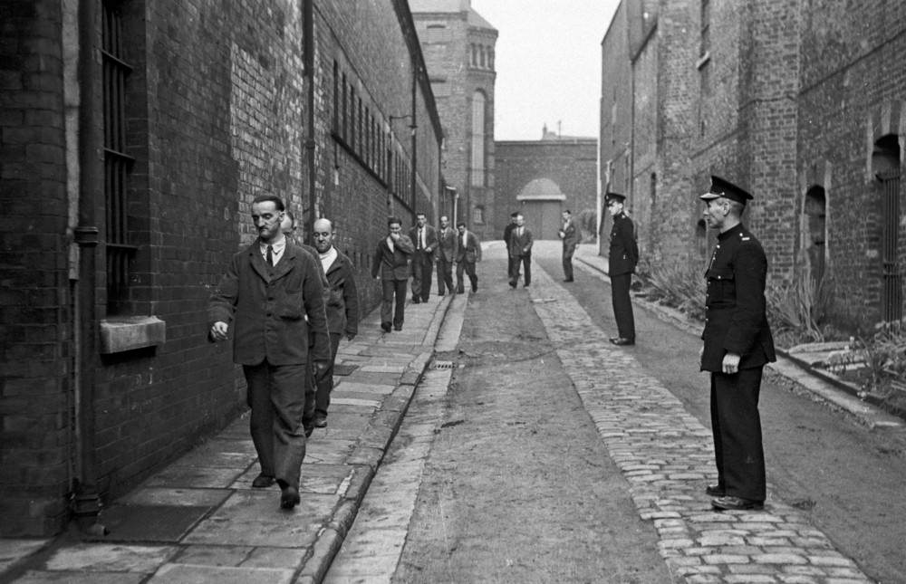#4 Prison officers watching prisoners return from their daily outdoor exercise at Strangeways Prison.