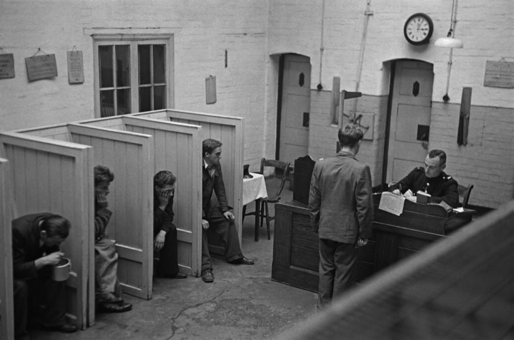 #5 Prison officer Davidson interviewing a group of new prisoners in the reception room at Strangeways Prison.