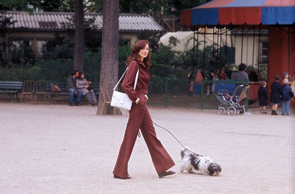 #26 Marisa Berenson walking with her dog.