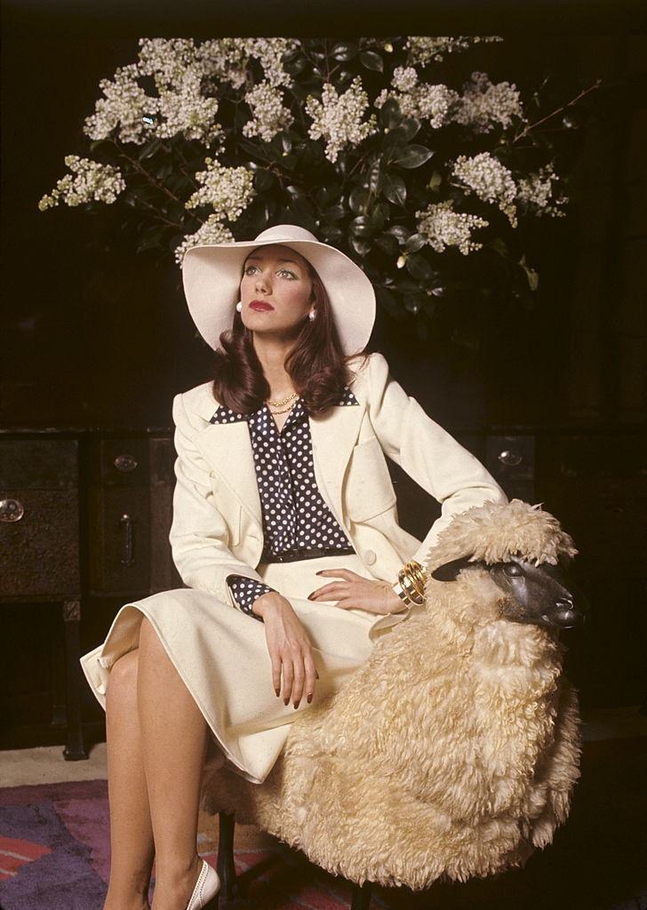 #30 Marisa Berenson wears a white gabardine suit over a polka-dot silk blouse, 1972.