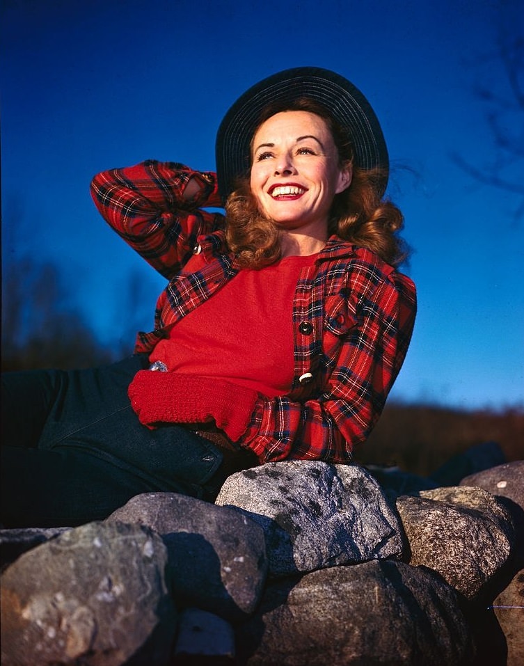 #8 Paulette Goddard poses atop rocks with her hand on her hat.