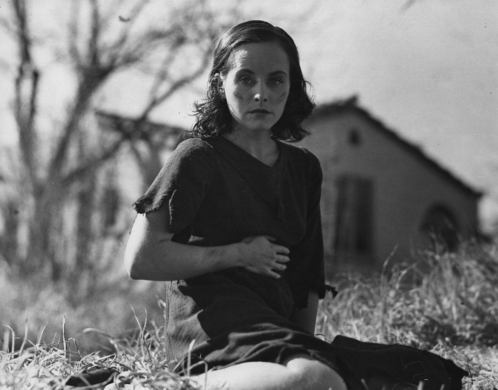 #51 Paulette Goddard wearing rags and sitting on the ground, 1936.