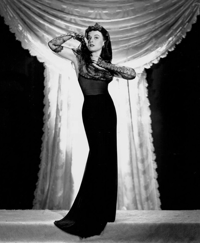 #60 Paulette Goddard wearing a black evening gown, for Paramount Pictures, 1940.