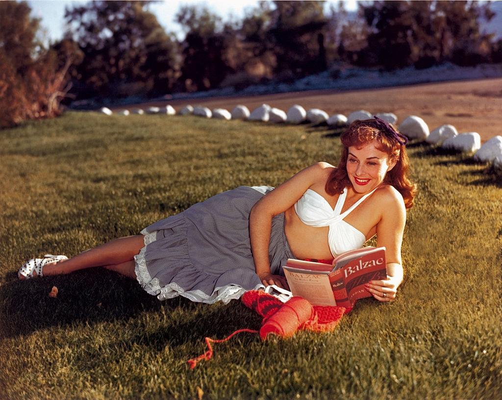 #64 Paulette Goddard reading a book in the park, 1940.