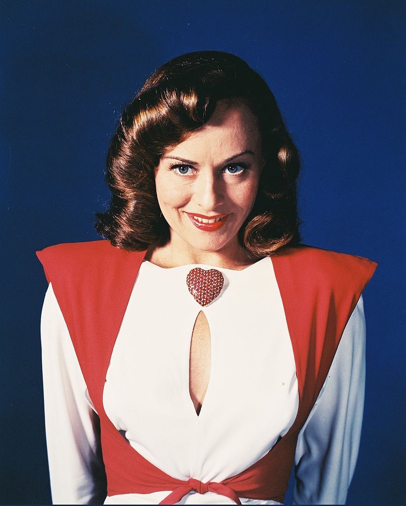#75 Paulette Goddard wearing a red-and-white blouse, with a keyhole neckline, and a large red heart-shaped brooch, 1945.