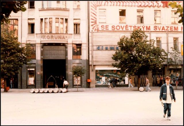#1 Barrels of beer are rolled to the front of the Koruna hotel under a sign extolling the virtues of state socialism