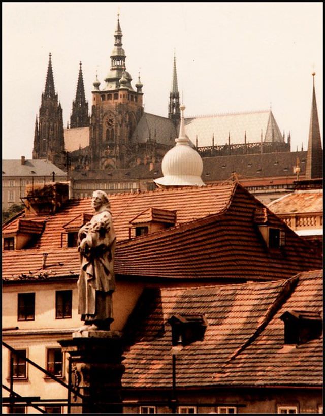 #43 St. Vitus Cathedral peeps above the houses of Malé Strana, with the Charles Bridge statue of St Philip Benizi in the foreground