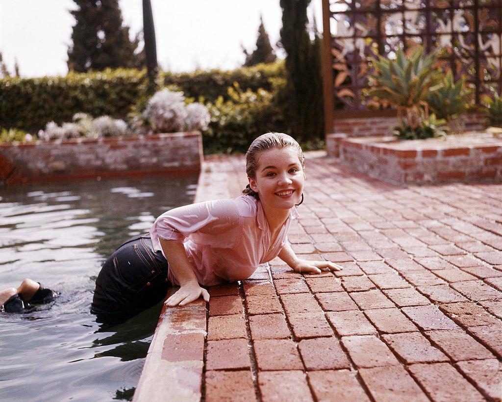 #34 Tuesday Weld emerging, fully-clothed from a swimming pool, 1960.