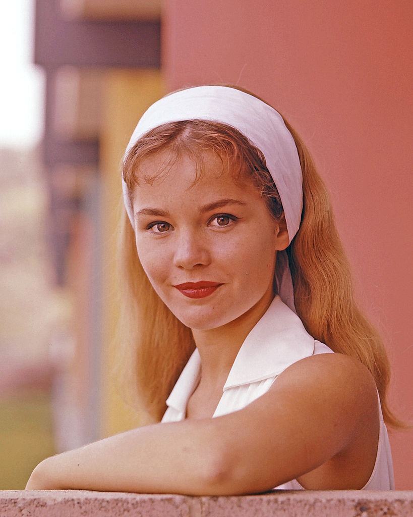 #17 Tuesday Weld wearing a white sleeveless top and a thick white headband, circa 1965.