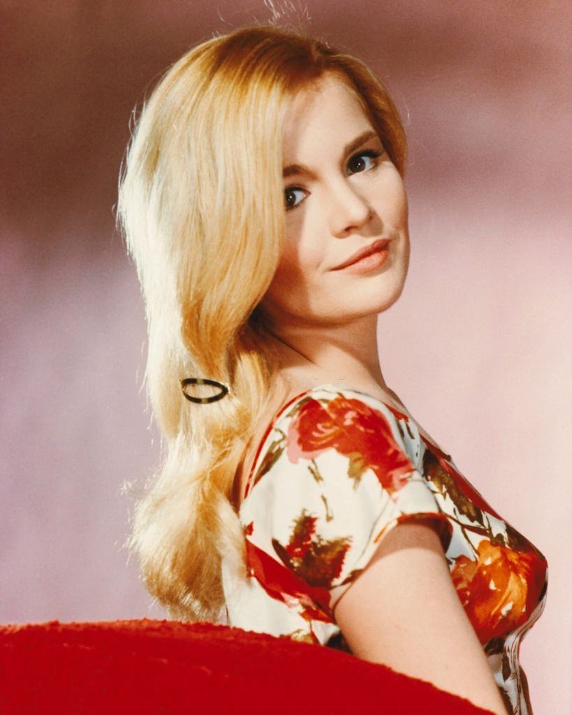 #53 Tuesday Weld wearing a floral print top in a studio portrait, 1965.
