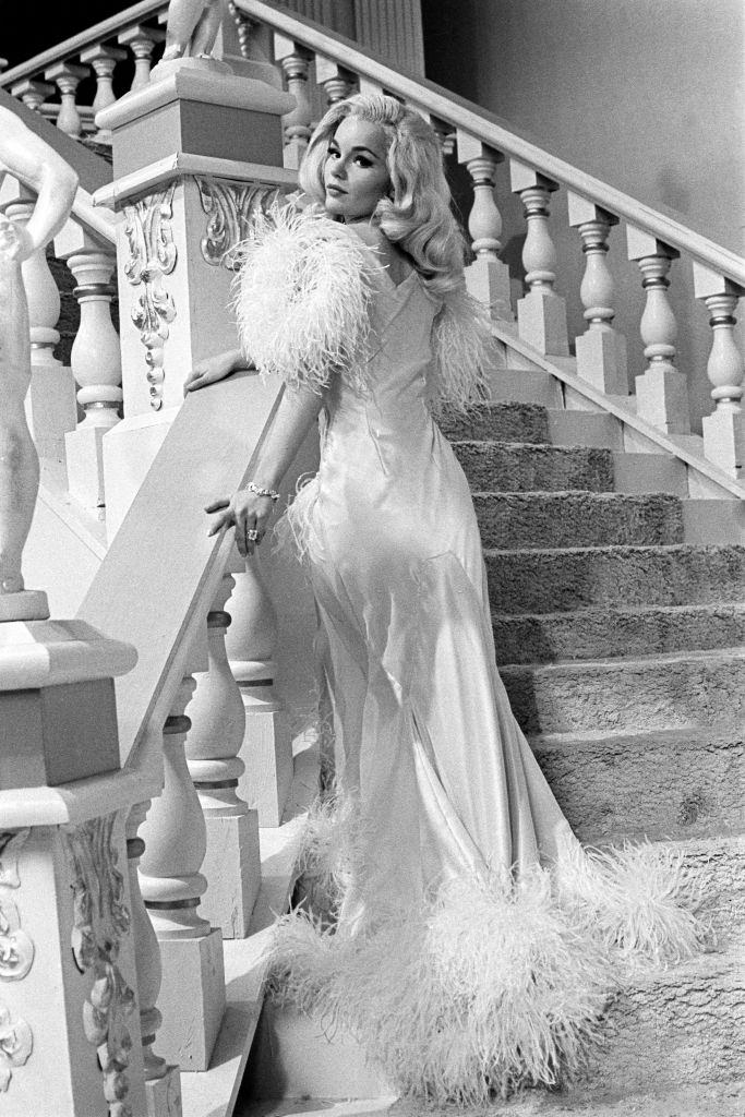 #58 Tuesday Weld in a white satin dress with white feathers, 1963.