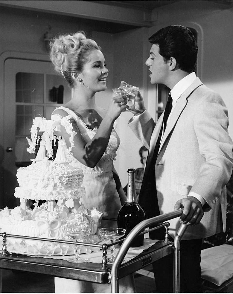 #18 Tuesday Weld and Frankie Avalon toast each other at wedding ceremony pointing at unidentified man in a scene from the film ‘I’ll Take Sweden’, 1965.