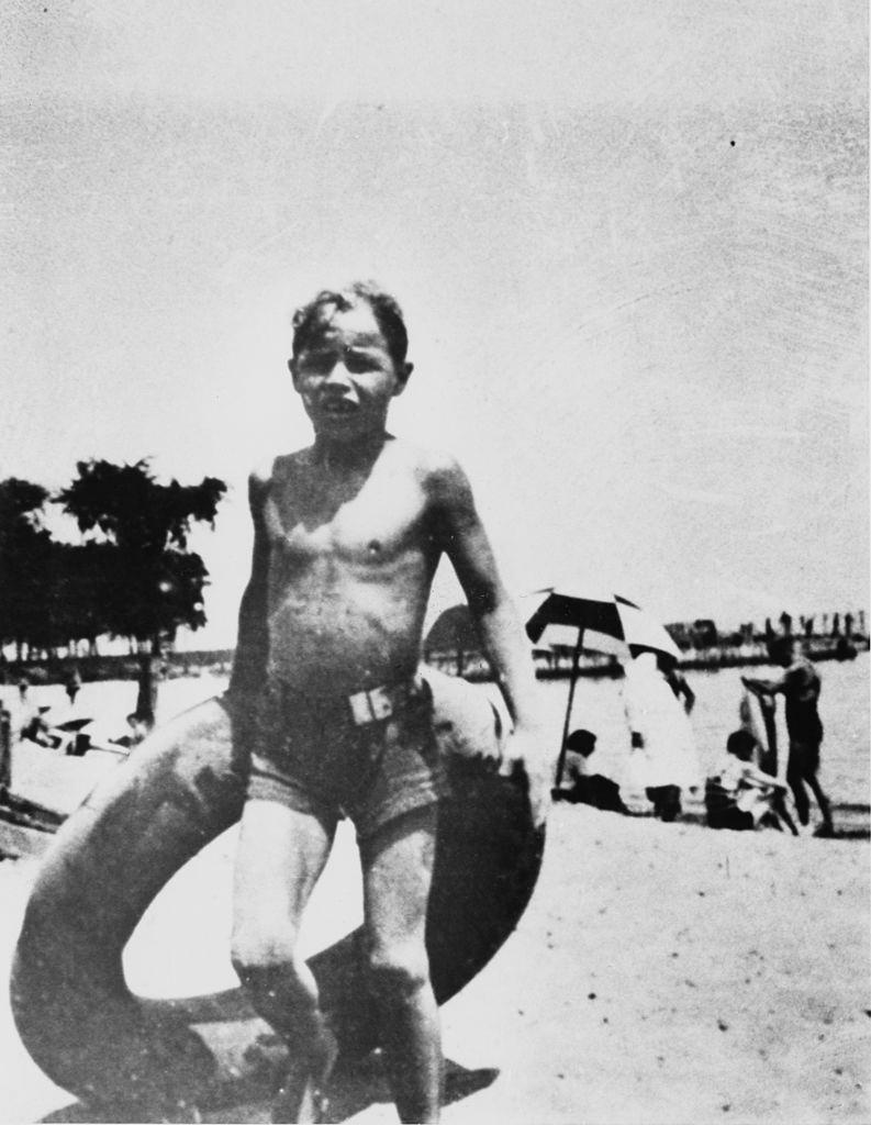#75 Marlon Brando holding an inflatable ring during a trip to a beach, 1932.