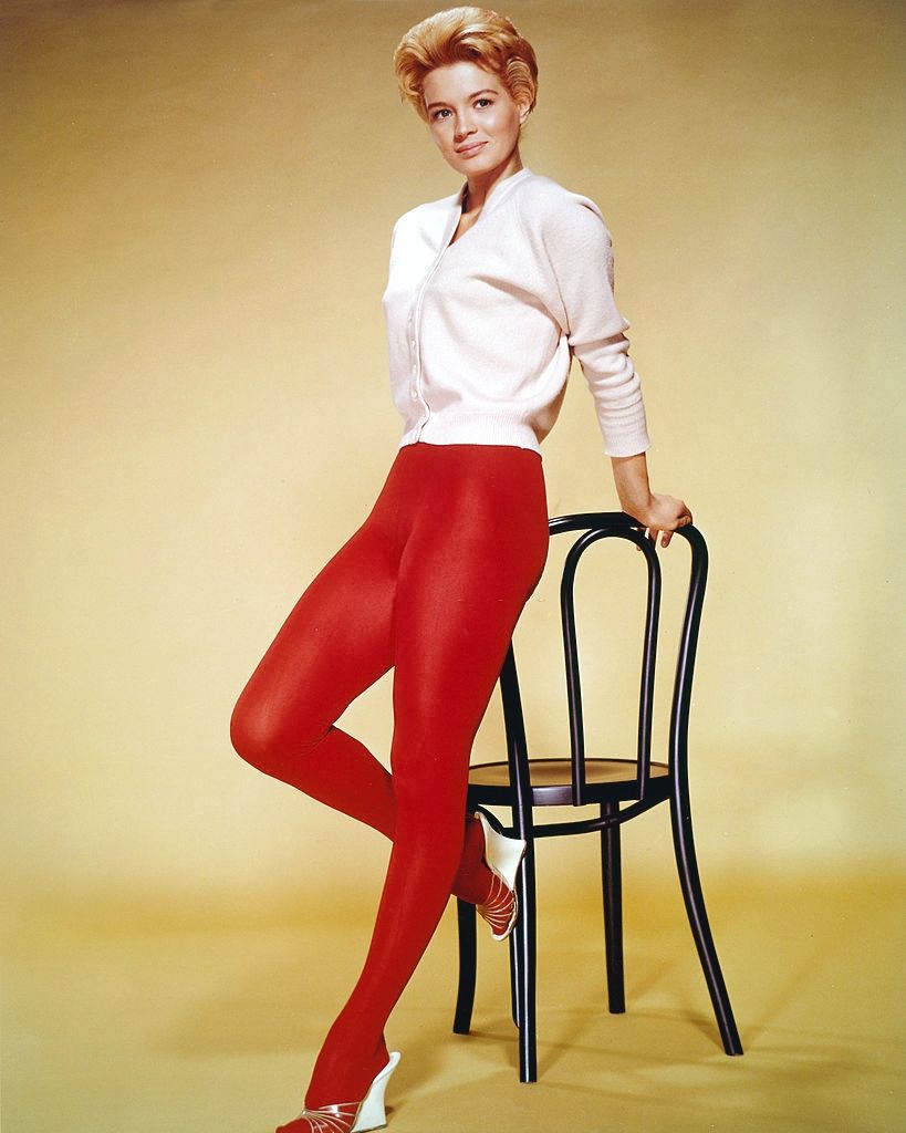 #3 Angie Dickinson wearing a white cardigan and red tights, 1955.