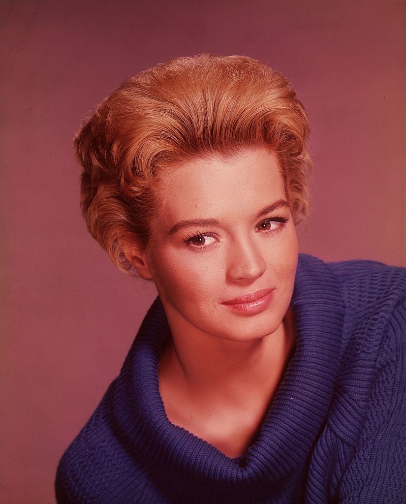 #24 Angie Dickinson smiling in a blue cowl-necked sweater, 1960.