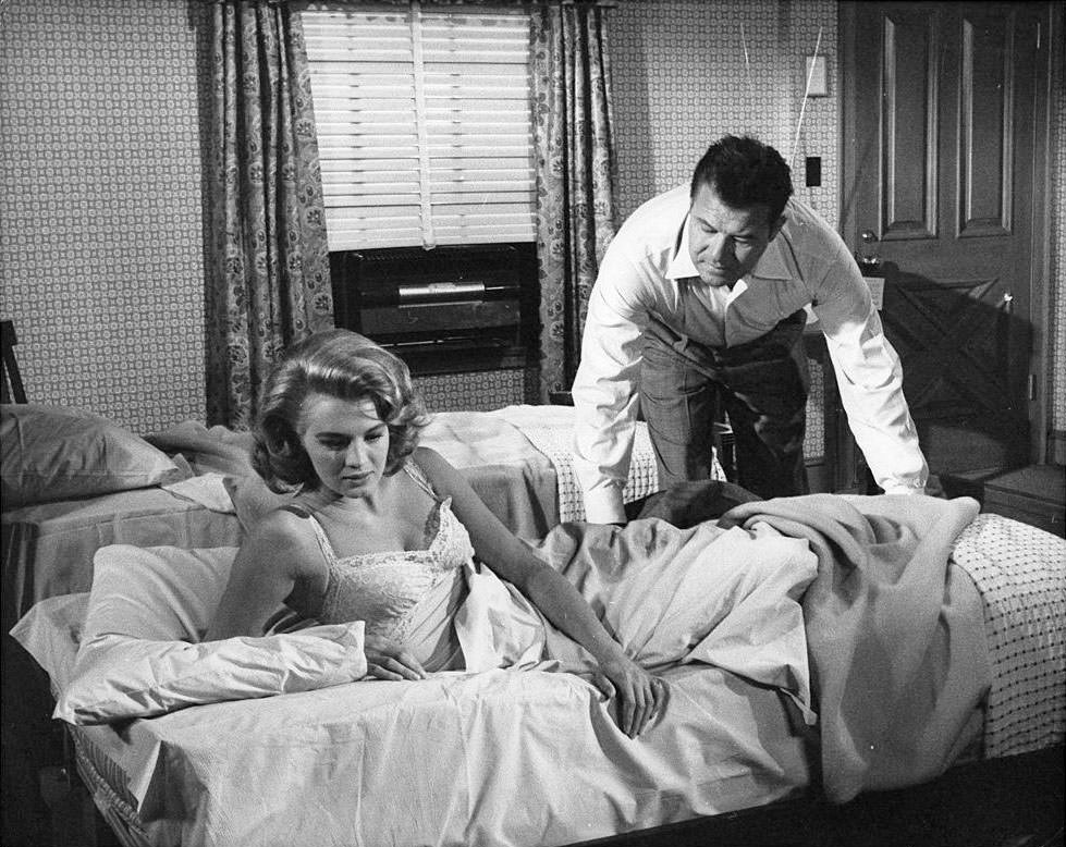 #26 Angie Dickinson and Jack Carson in a motel room scene from the film ‘The Bramble Bush’, 1960.