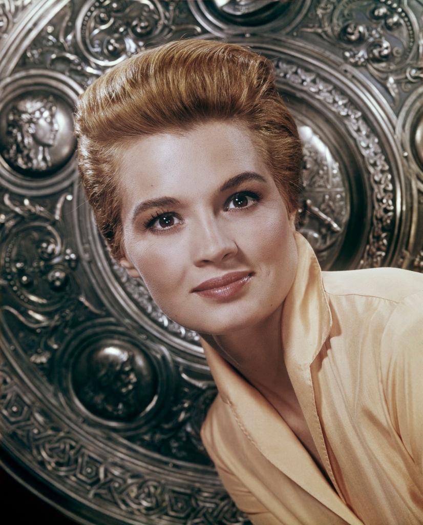 #29 Angie Dickinson in front of an embossed shield, 1960.