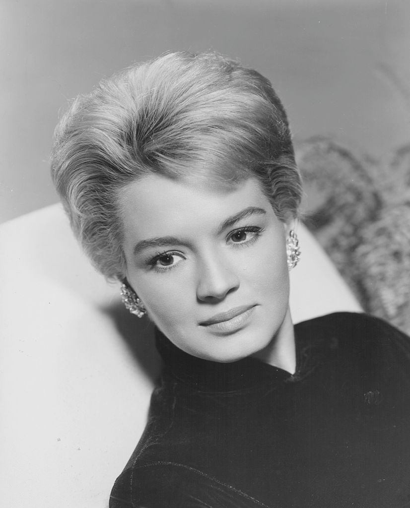 #11 Angie Dickinson, wearing a high necked blouse and earrings, 1955.