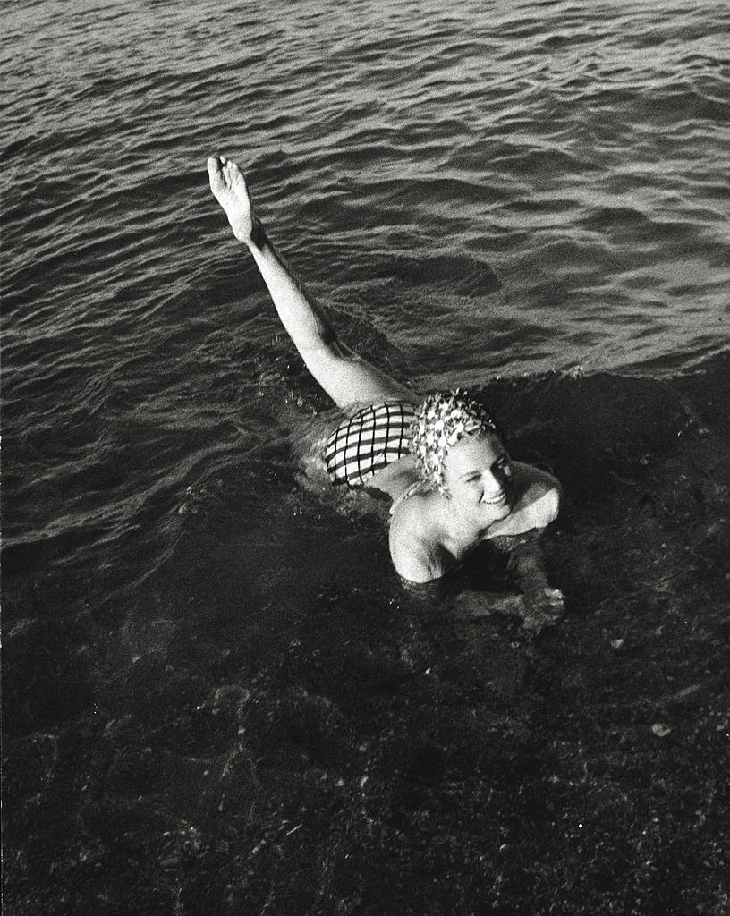 #54 Angie Dickinson taking a bath near the shore, 1961.