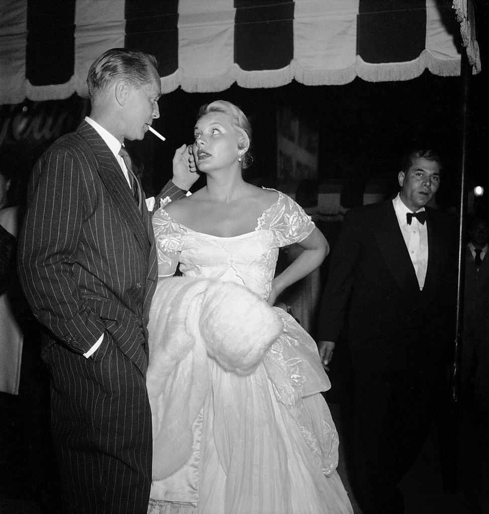 #19 Barbara Payton with Franchot Tone waiting outside Mocambo nightclub, 1951.