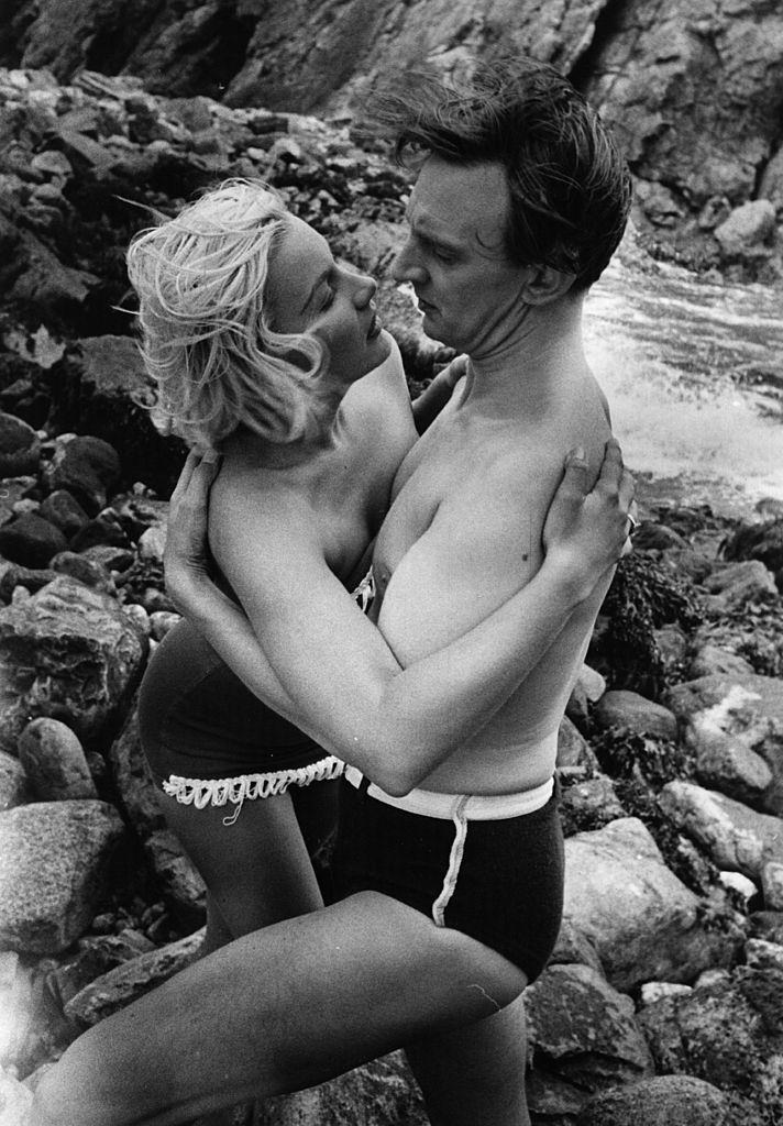 #42 Barbara Payton with Stephen Murray on the beach during the filming of ‘The Four Sided Triangle’ , 1952.