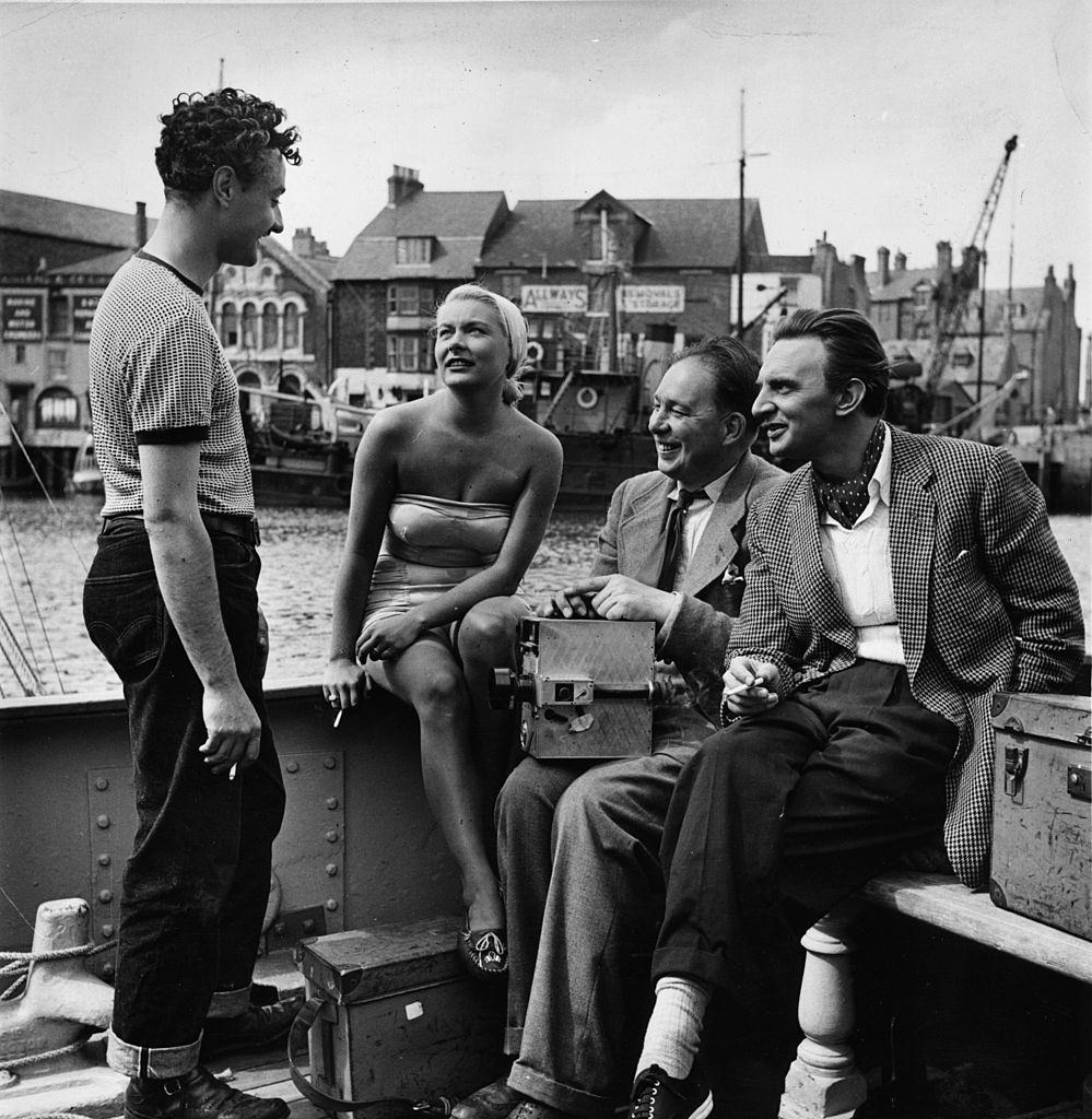 #44 Barbara Payton chats to Michael Carreras producer of a British film, ‘The Four Sided Triangle’, 1952.