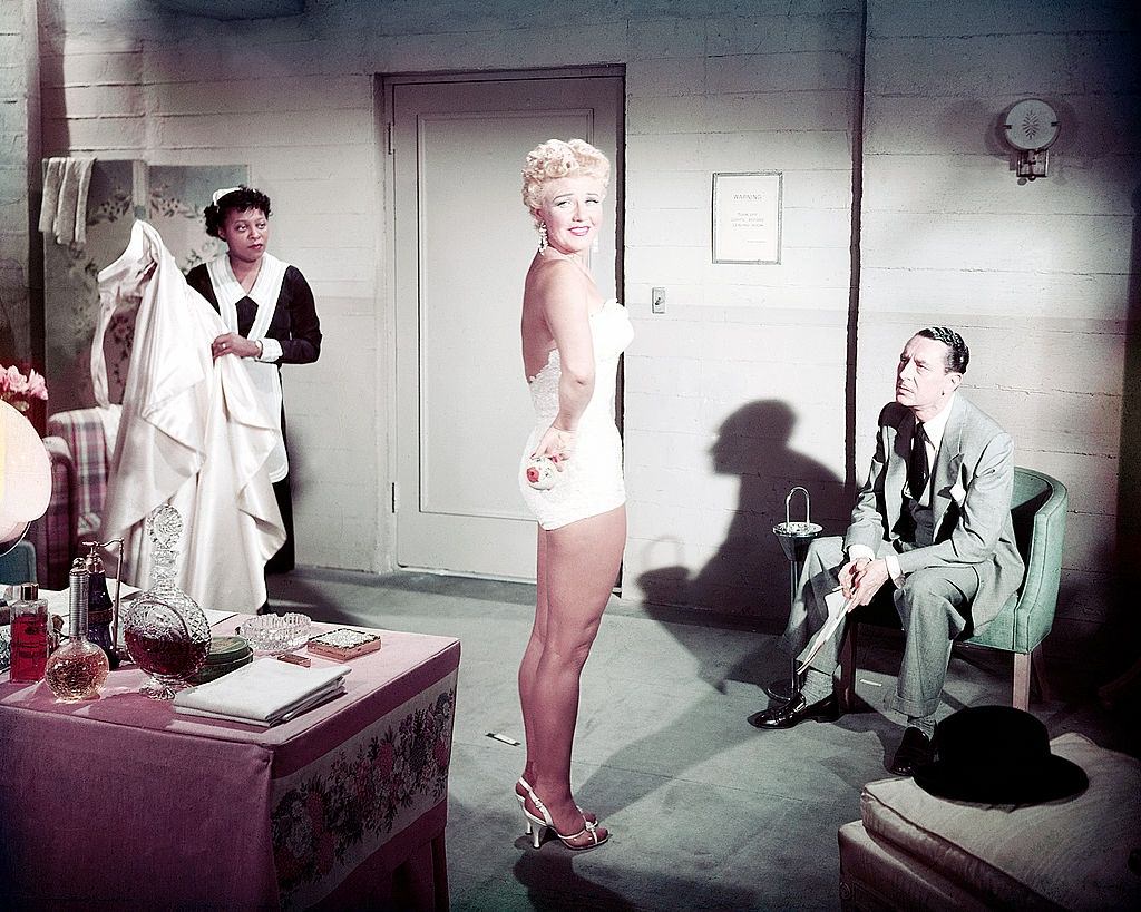 #75 Betty Grable wearing a one-piece swimsuit in a dressing room, 1945