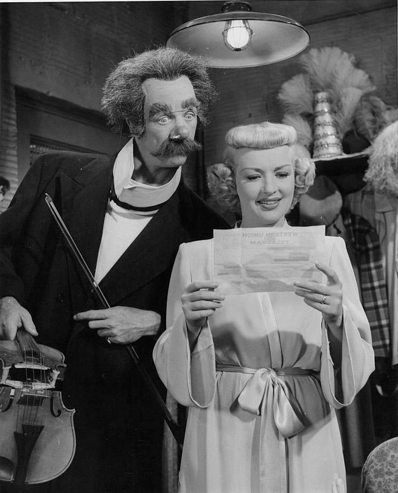 #59 Betty Grable reading a telegraph while Dan Dailey is look it, 1948.
