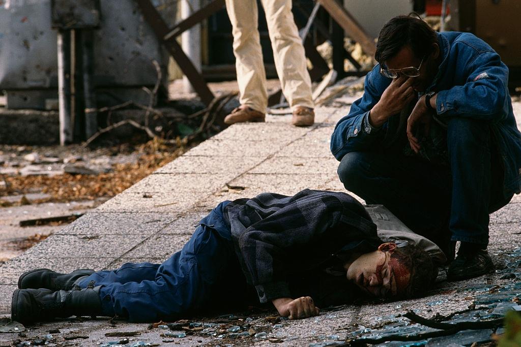 #1 A man mourns next to the body of a civilian victim of the siege of Sarajevo who was killed by a sniper.