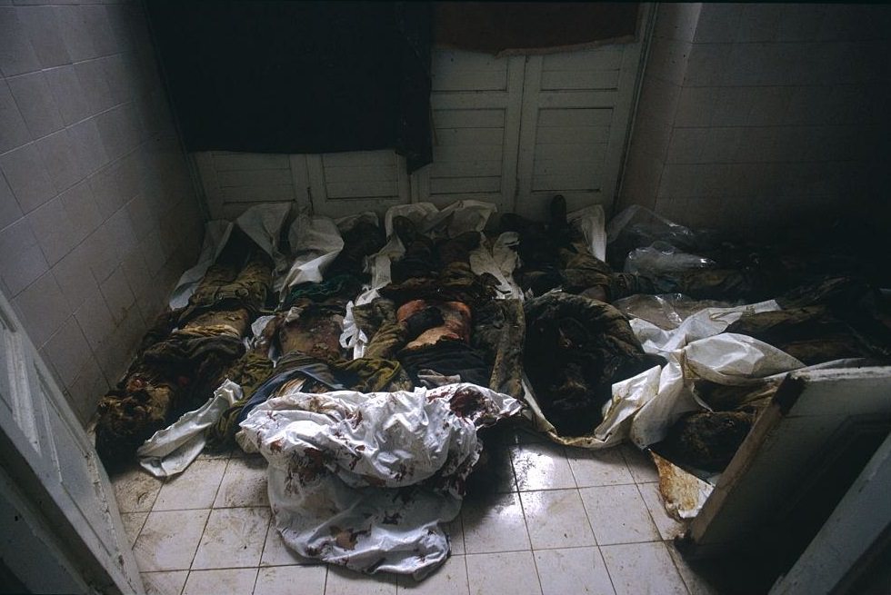 #50 The corpses of civilians killed during the siege of Sarajevo lie on the floor of a morgue in Sarajevo. Some bodies are still in their clothes while others are wrapped in sheets.