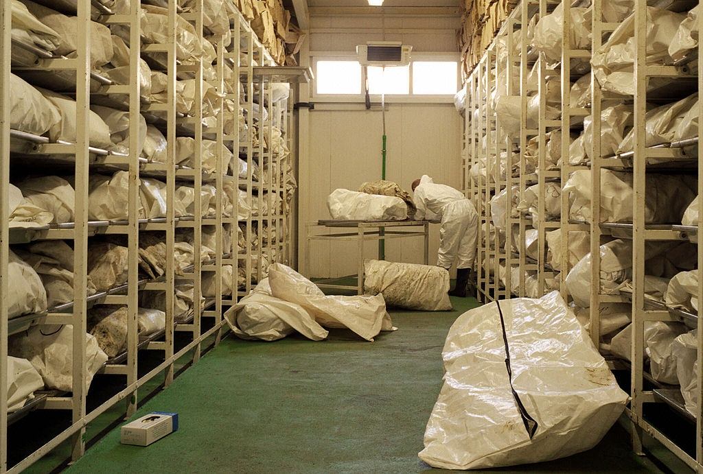 #53 A pathologist uncovers one of the 4.000 bags inside of giant refrigerator in Tuzla. The remains of the bodies of Muslim men and boys massacred in eastern Bosnian town of Srebrenica in 1995.