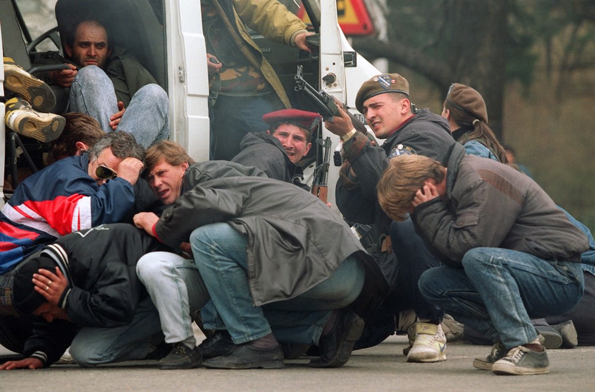 #16 A Bosnian special forces soldier returns fire in downtown Sarajevo as he and civilians come under fire from Serbian snipers, on April 6, 1992.