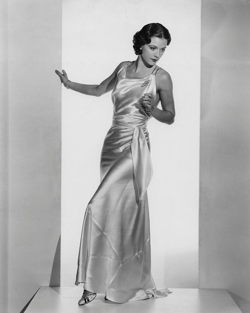 #42 Eleanor Powell wearing a white satin formal gown, 1935.