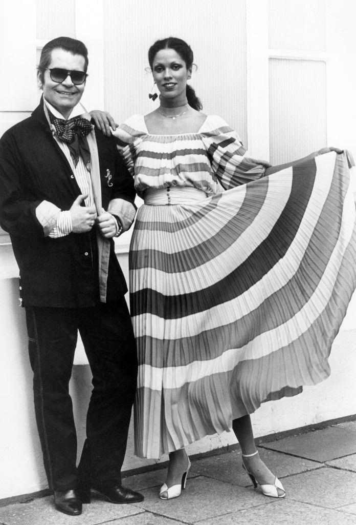 #17 Karl Lagerfeld next to a model in a pleated dress from Lagerfeld’s Chloe collection, 1977.