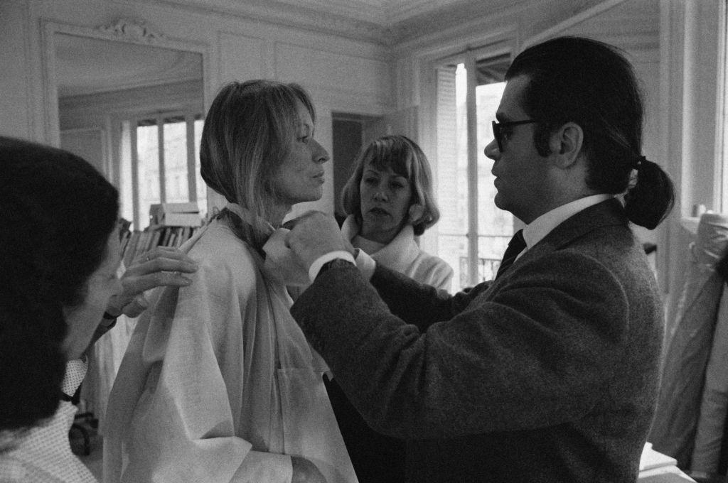#24 Karl Lagerfeld fixing a model’s collar, 1979.