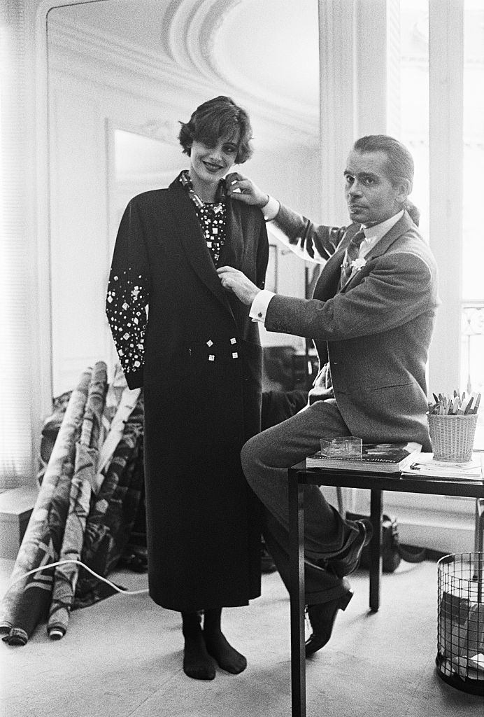 #48 Karl Lagerfeld fits one of his designs on top model Ines de la Fressange at Chloe’s Paris studio.