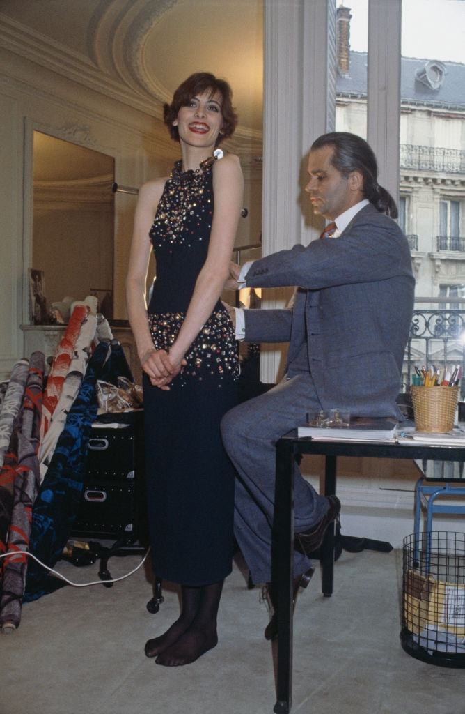 #50 Karl Lagerfeld fits one of his designs on top model Ines de la Fressange at Chloe’s Paris studio.